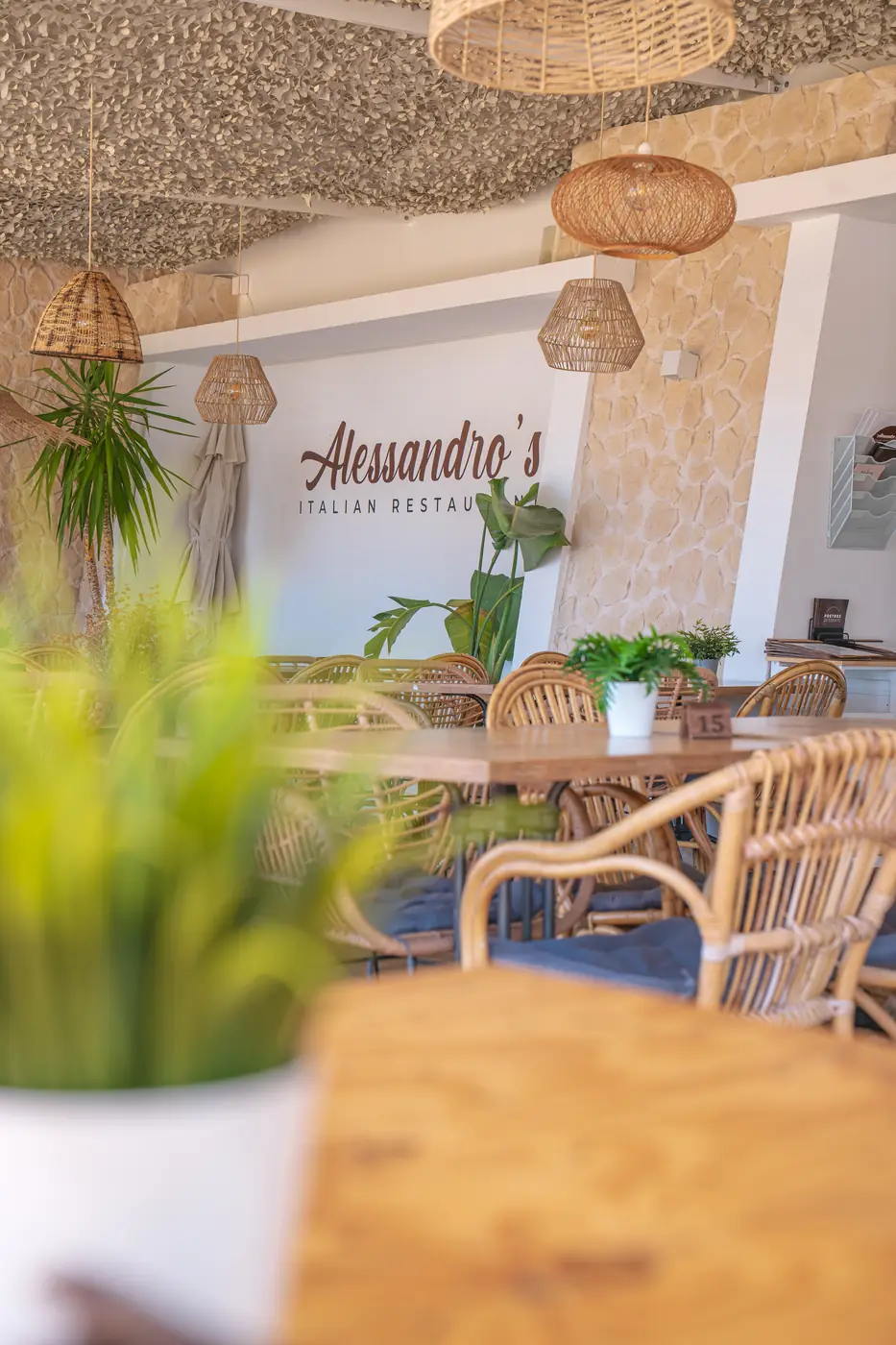Interior de Alessandro's con ratán y el logo